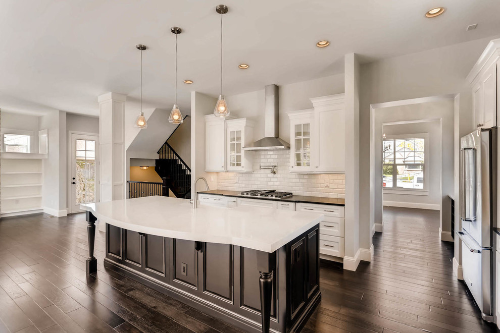 Large transitional l-shaped dark wood floor and brown floor open concept kitchen photo in Denver with recessed-panel cabinets, white cabinets, ceramic backsplash, stainless steel appliances and an island