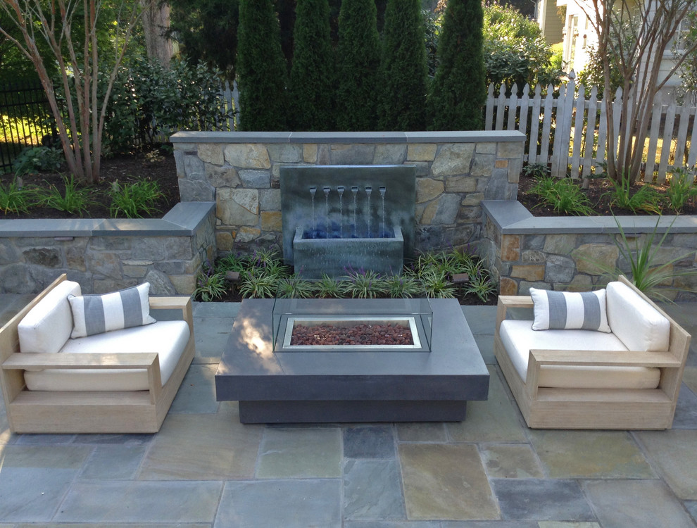 Mid-sized contemporary backyard patio in DC Metro with a water feature, natural stone pavers and no cover.