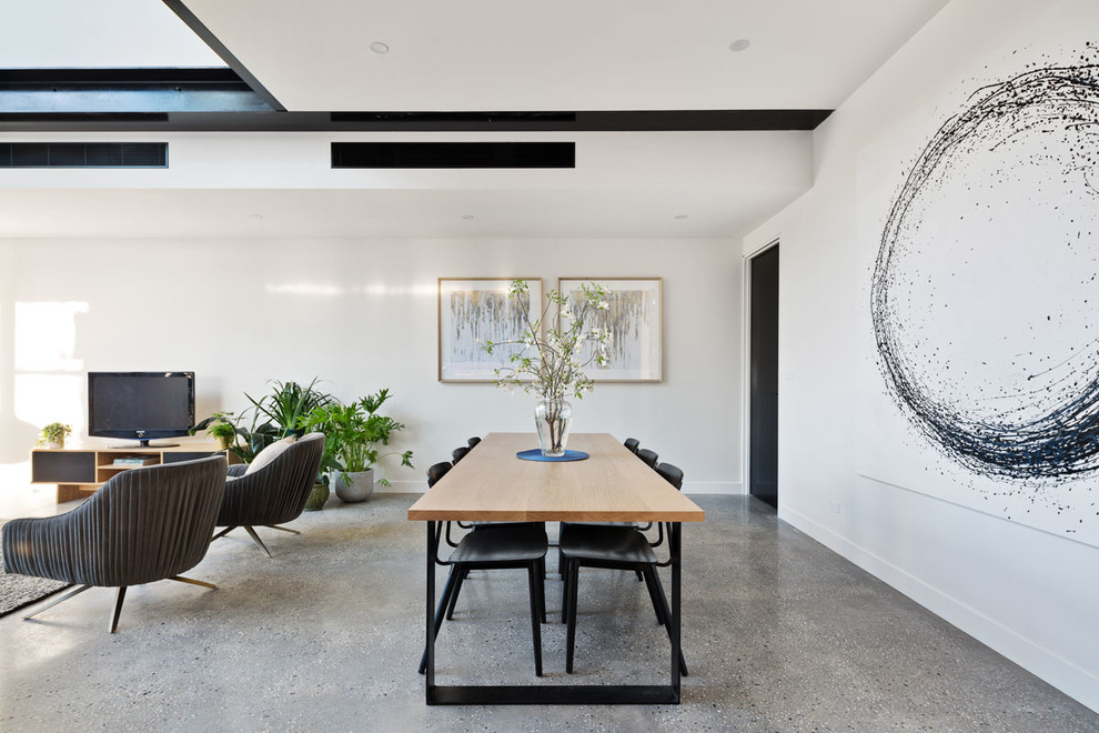 Photo of a mid-sized contemporary open plan dining in Melbourne with white walls and concrete floors.