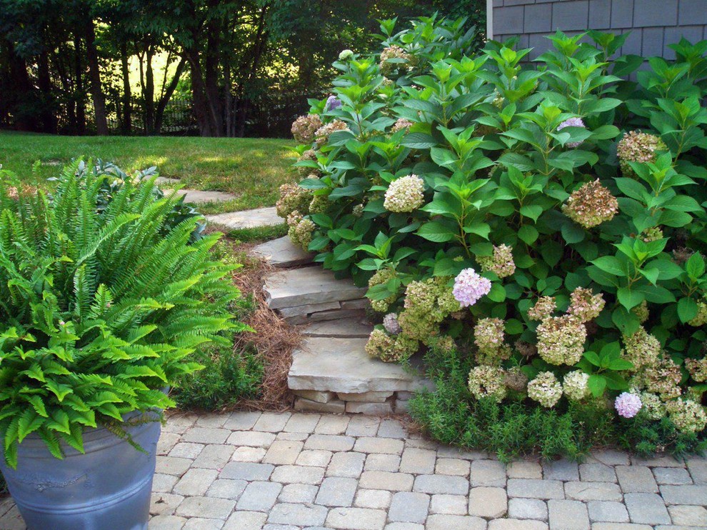 This is an example of a mid-sized transitional partial sun backyard concrete paver landscaping.