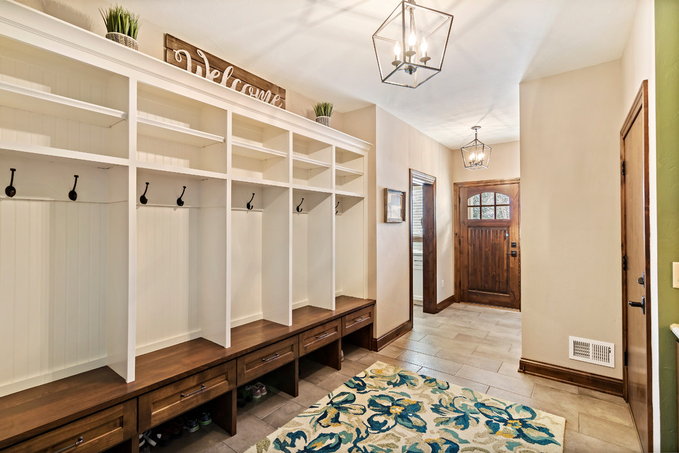 Photo of a mid-sized country mudroom in Charleston with beige walls, ceramic floors, a single front door, a dark wood front door and beige floor.