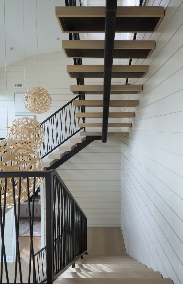 Inspiration for a transitional wood floating staircase in Philadelphia with open risers and metal railing.
