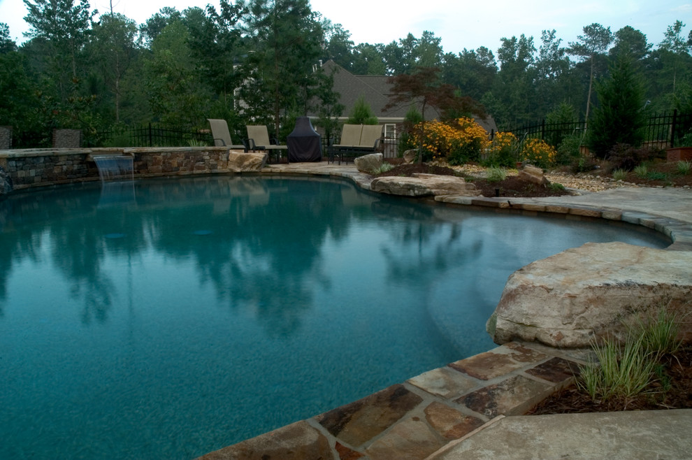 Mid-sized mountain style backyard stone and kidney-shaped hot tub photo in Atlanta