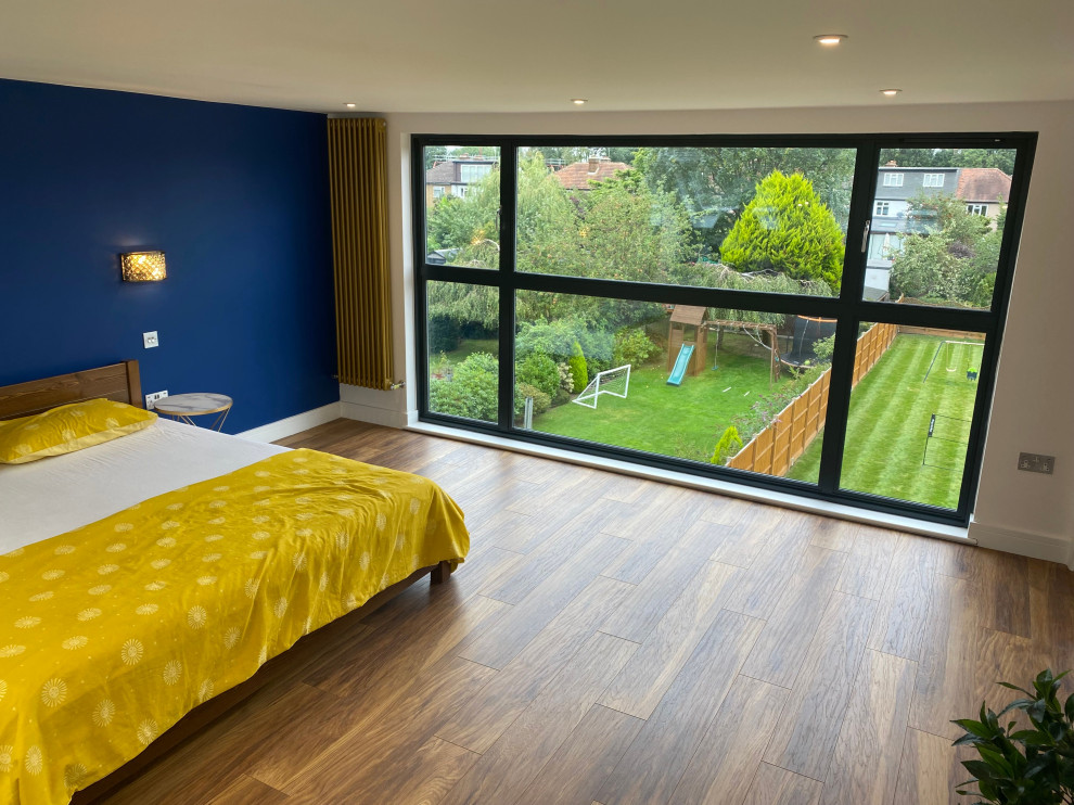 Großes Schlafzimmer mit blauer Wandfarbe, Bambusparkett, braunem Boden, Deckengestaltungen und Wandgestaltungen in London