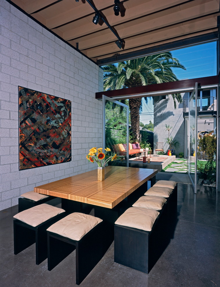 Photo of a modern kitchen/dining combo in Los Angeles with white walls, concrete floors and grey floor.