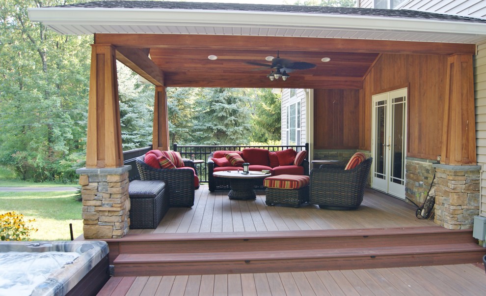 Photo of a mid-sized arts and crafts backyard deck in New York with a water feature and a roof extension.