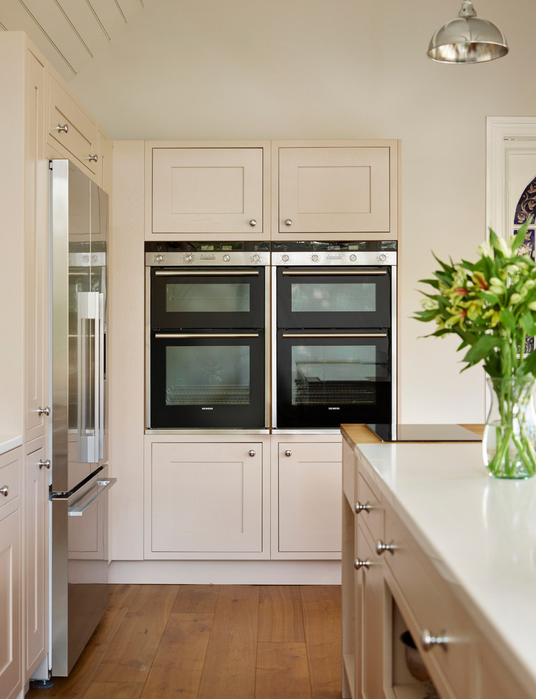 Inspiration for a traditional kitchen in Essex with medium hardwood flooring and an island.