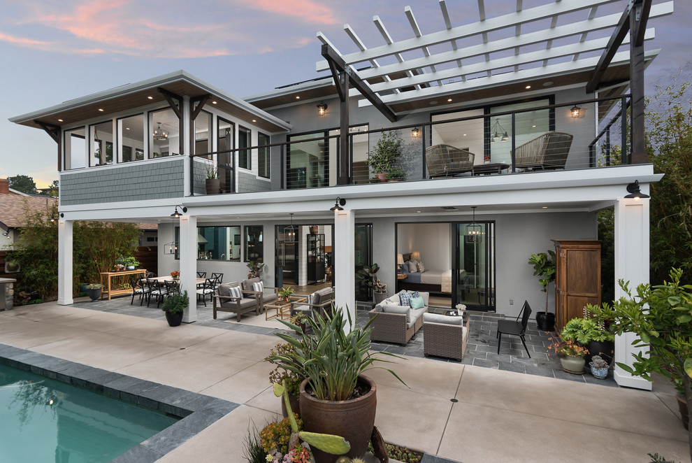 Mid-sized arts and crafts two-storey grey house exterior in San Diego with a hip roof and a metal roof.