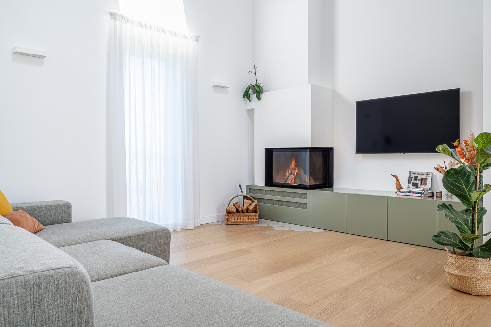 Cette image montre un grand salon design ouvert avec un mur blanc, une cheminée d'angle, un manteau de cheminée en plâtre et un téléviseur fixé au mur.