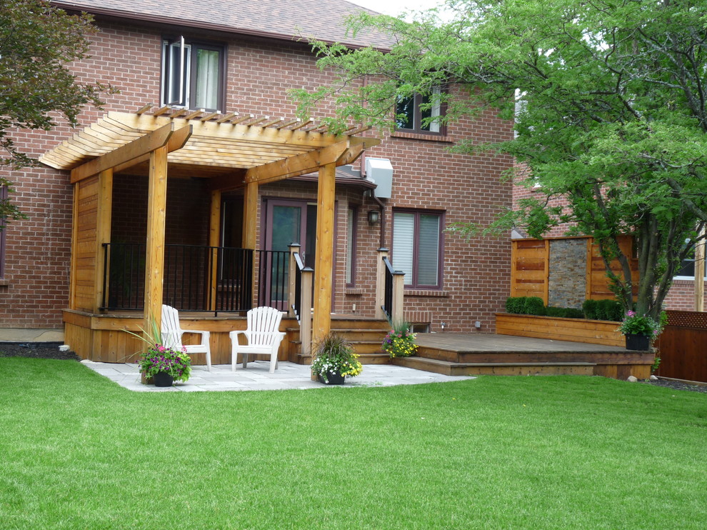 Inspiration for a large modern backyard deck remodel in Toronto with a pergola