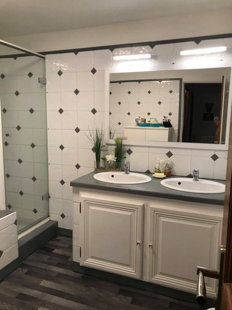 Foto på ett grå badrum, med vita skåp, ett undermonterat badkar, våtrum, vit kakel, keramikplattor, vita väggar, linoleumgolv, ett undermonterad handfat, kaklad bänkskiva, grått golv och dusch med gångjärnsdörr