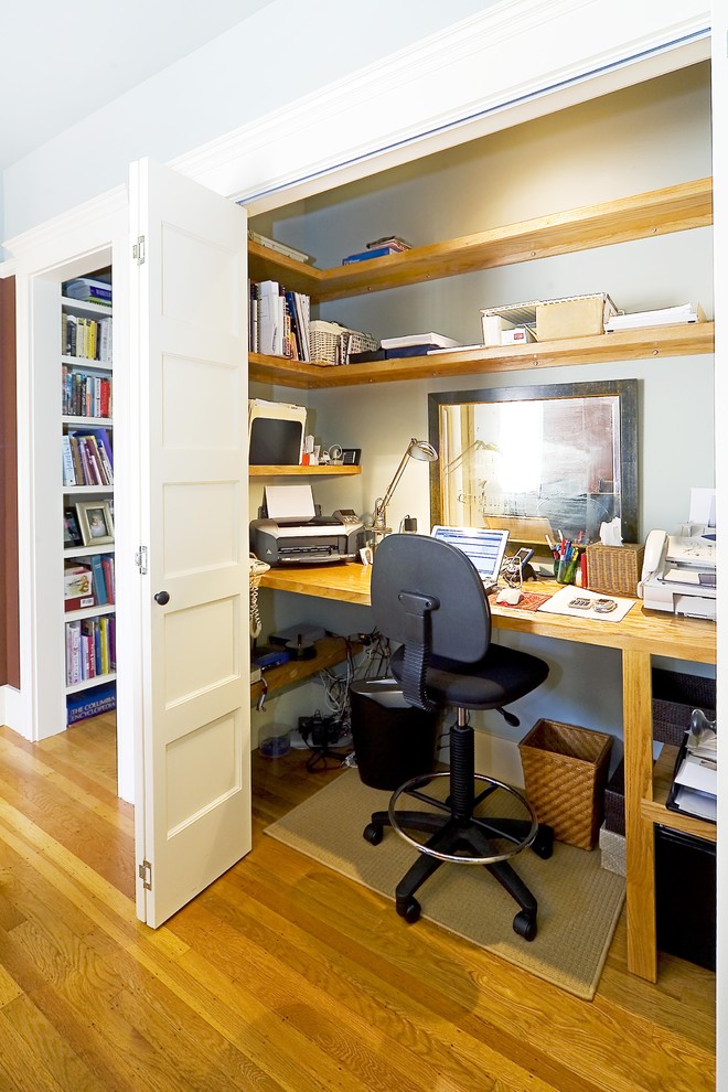 This is an example of a traditional home office in San Francisco with grey walls, medium hardwood floors and a built-in desk.