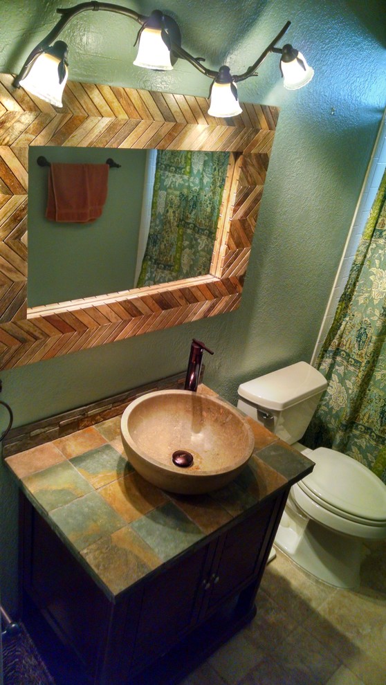 Small mountain style multicolored tile and stone tile travertine floor bathroom photo in Phoenix with furniture-like cabinets, dark wood cabinets, a two-piece toilet, green walls, a vessel sink and tile countertops