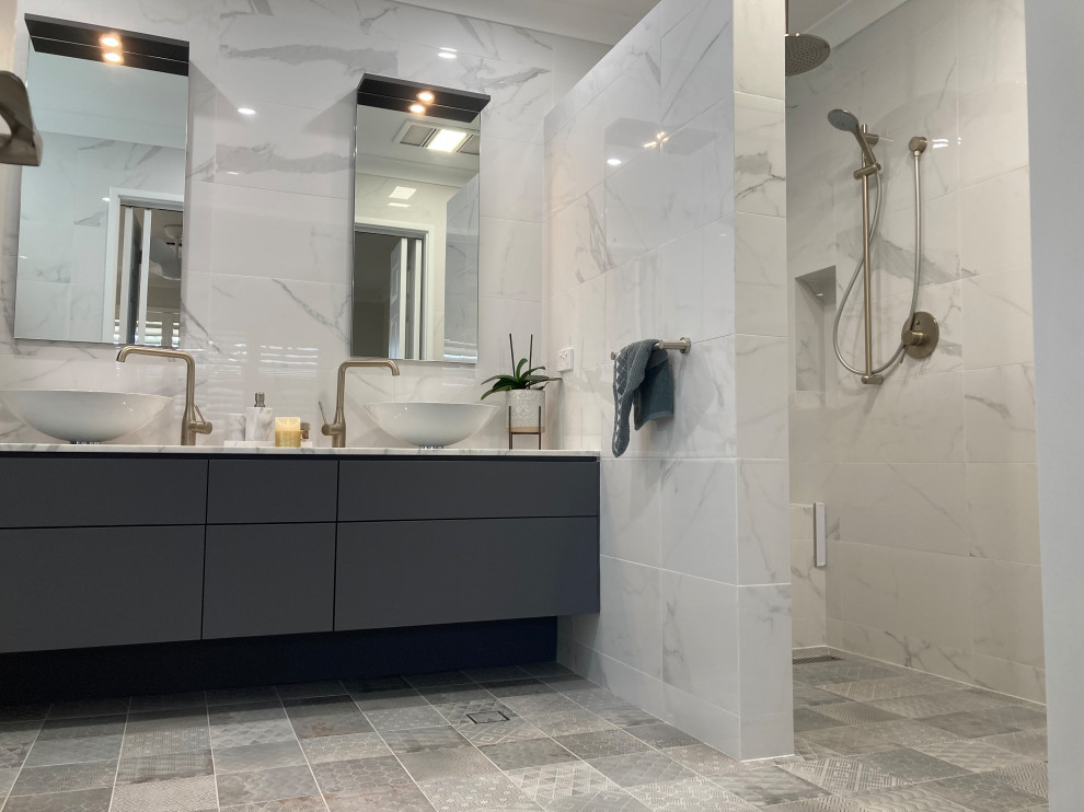 Inspiration for an expansive contemporary master bathroom in Perth with flat-panel cabinets, grey cabinets, an open shower, a wall-mount toilet, white tile, marble, white walls, mosaic tile floors, a vessel sink, marble benchtops, grey floor, white benchtops, a shower seat, a double vanity and a built-in vanity.