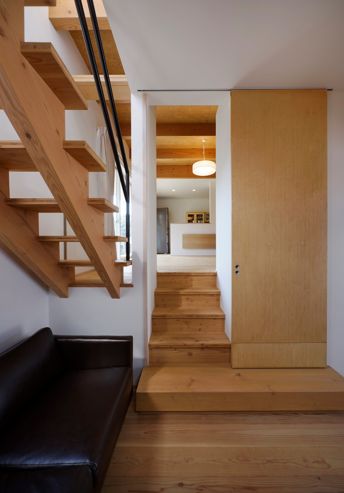 Photo of a medium sized midcentury wood wood railing staircase in Other with wood risers and wallpapered walls.