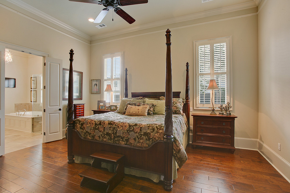 Inspiration for a large traditional master bedroom in New Orleans with beige walls and dark hardwood floors.