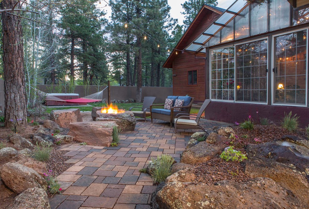 Patio - large rustic backyard brick patio idea in Phoenix with a fire pit and no cover