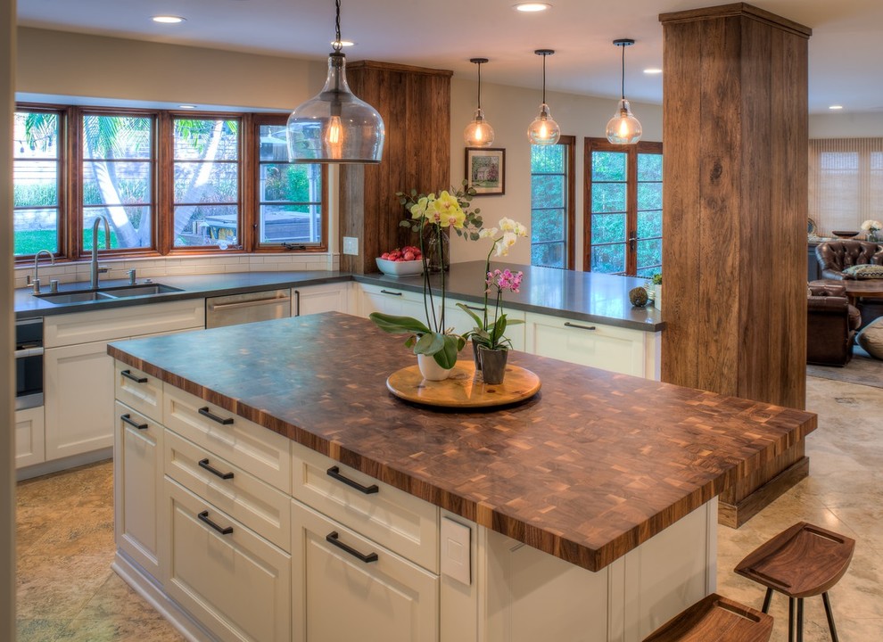 Photo of a mid-sized country u-shaped open plan kitchen in Denver with an undermount sink, recessed-panel cabinets, white cabinets, quartzite benchtops, white splashback, subway tile splashback, stainless steel appliances, travertine floors, with island and beige floor.
