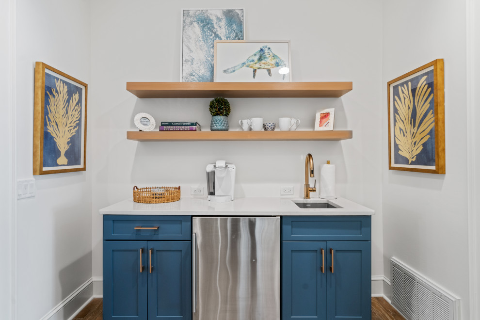 Mid-sized beach style single-wall wet bar in Other with medium hardwood floors, an undermount sink, shaker cabinets, blue cabinets, brown floor and white benchtop.