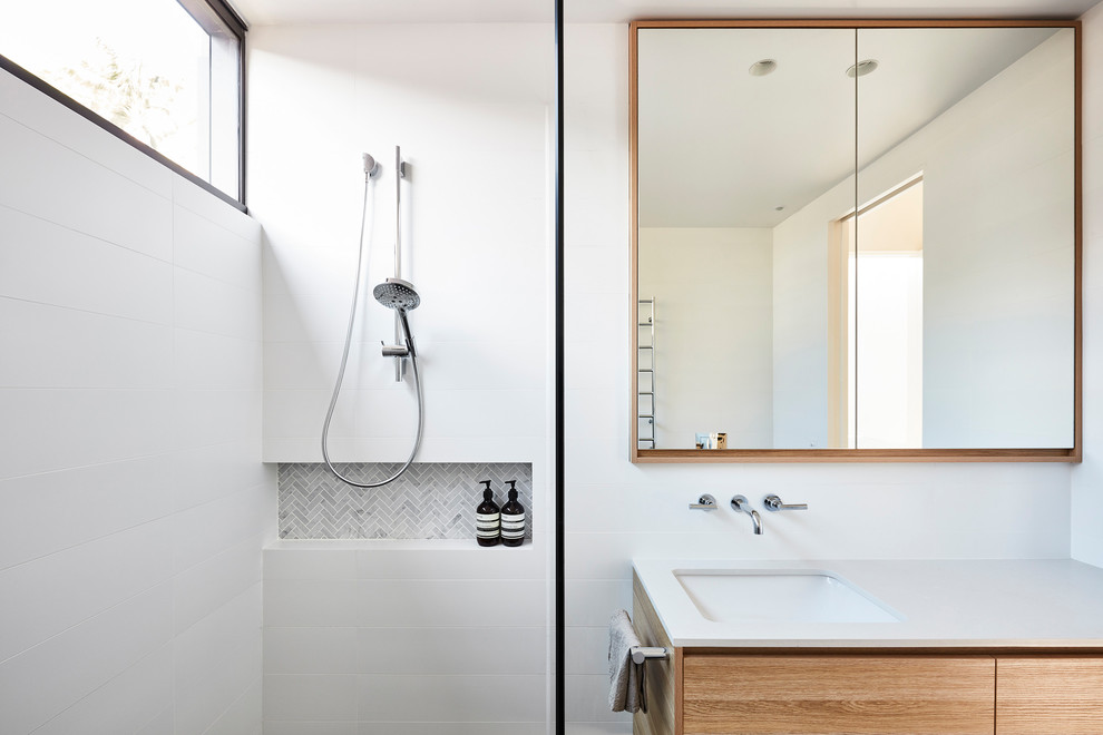Photo of a large contemporary master bathroom in Sydney with flat-panel cabinets, a drop-in tub, an open shower, a one-piece toilet, white tile, ceramic tile, white walls, ceramic floors, an undermount sink, engineered quartz benchtops, black floor, an open shower and white benchtops.