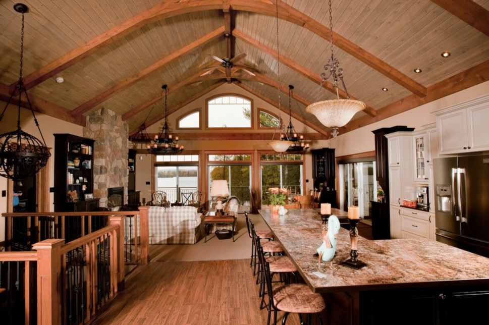 Example of a large mountain style galley light wood floor open concept kitchen design in Boston with an undermount sink, shaker cabinets, dark wood cabinets, granite countertops, stainless steel appliances and an island