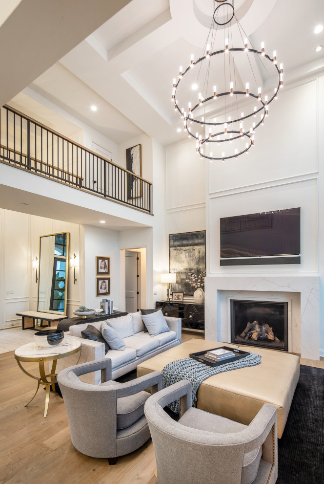 Inspiration for an expansive transitional formal open concept living room in Omaha with white walls, light hardwood floors, a standard fireplace, a stone fireplace surround, a wall-mounted tv, coffered and panelled walls.