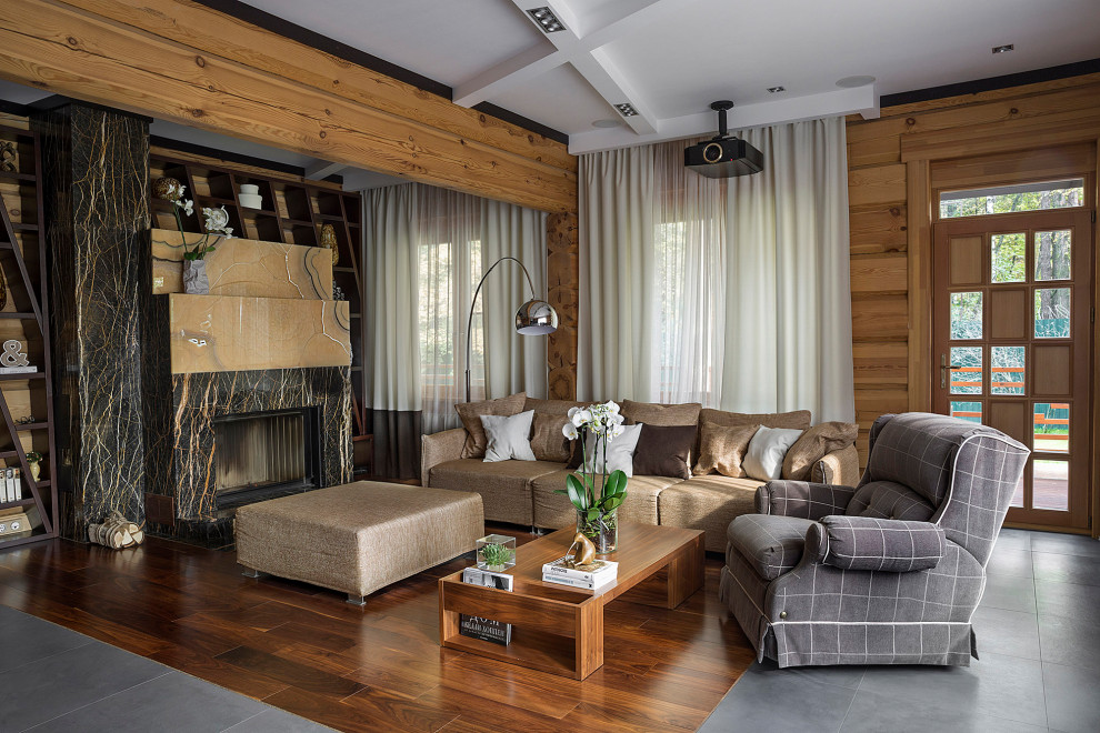 На фото: гостиная комната с фасадом камина из камня, коричневым полом, деревянным потолком и деревянными стенами