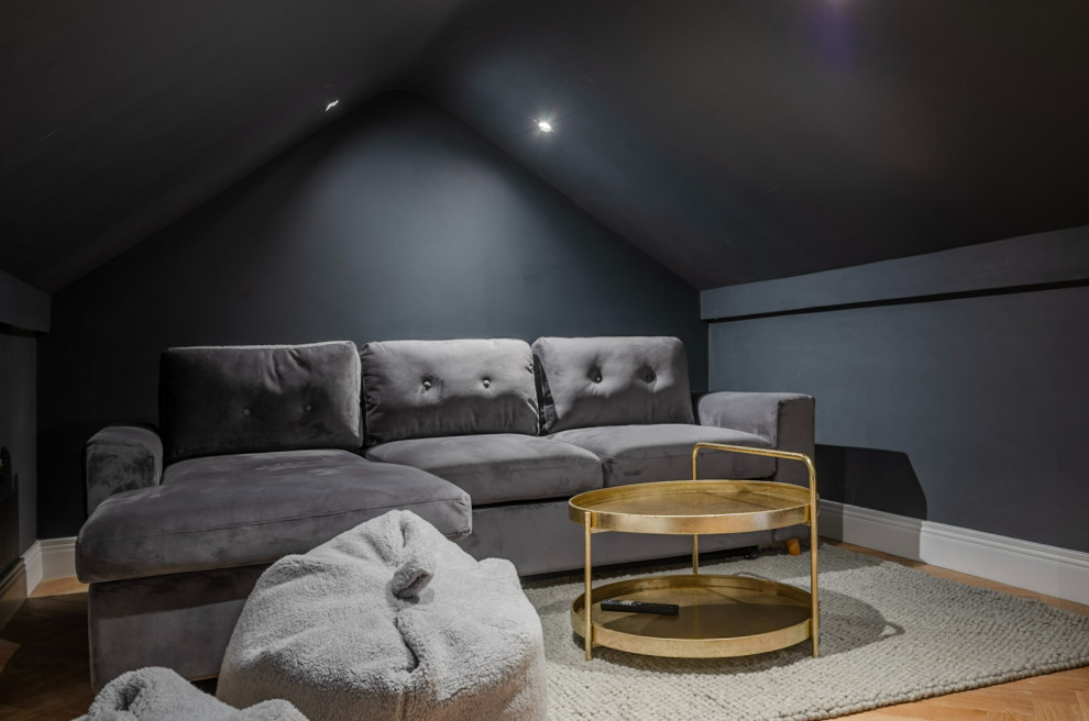 Immagine di un home theatre moderno di medie dimensioni e chiuso con pareti nere, pavimento in legno massello medio, TV a parete e pavimento marrone