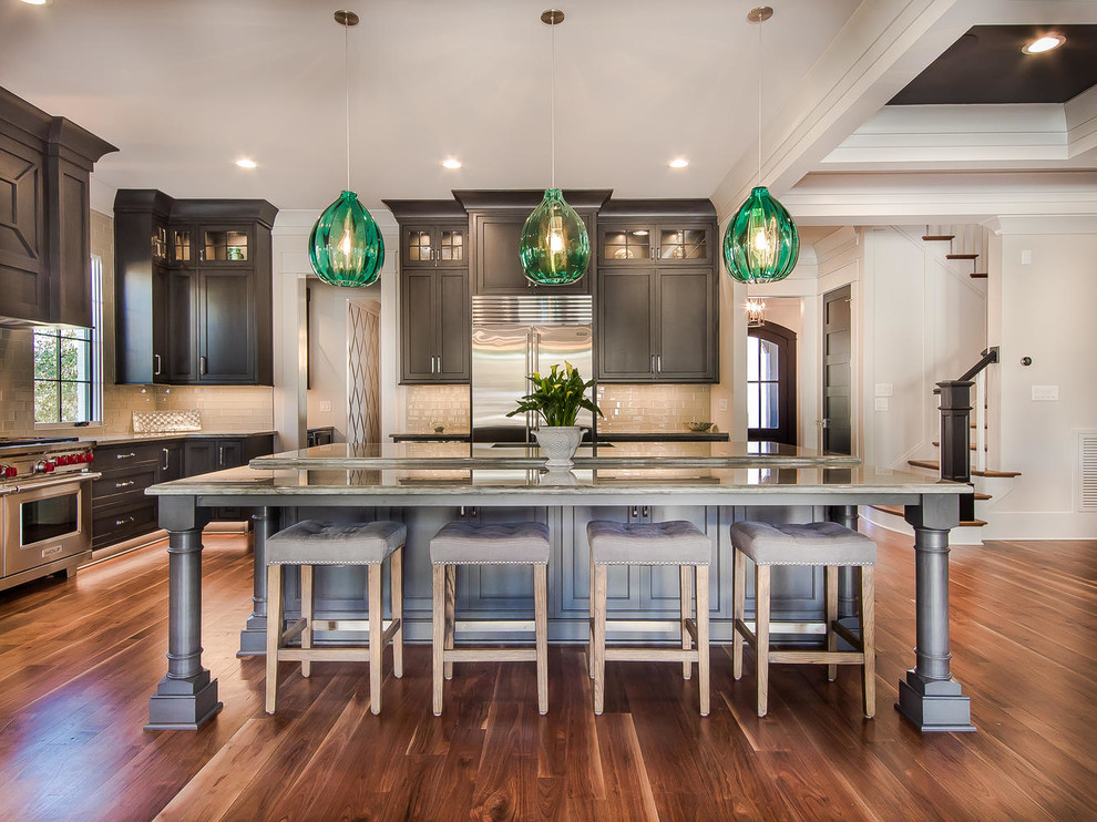 Large transitional l-shaped dark wood floor and brown floor enclosed kitchen photo in Raleigh with subway tile backsplash, stainless steel appliances, an undermount sink, recessed-panel cabinets, blue cabinets, granite countertops, gray backsplash and two islands