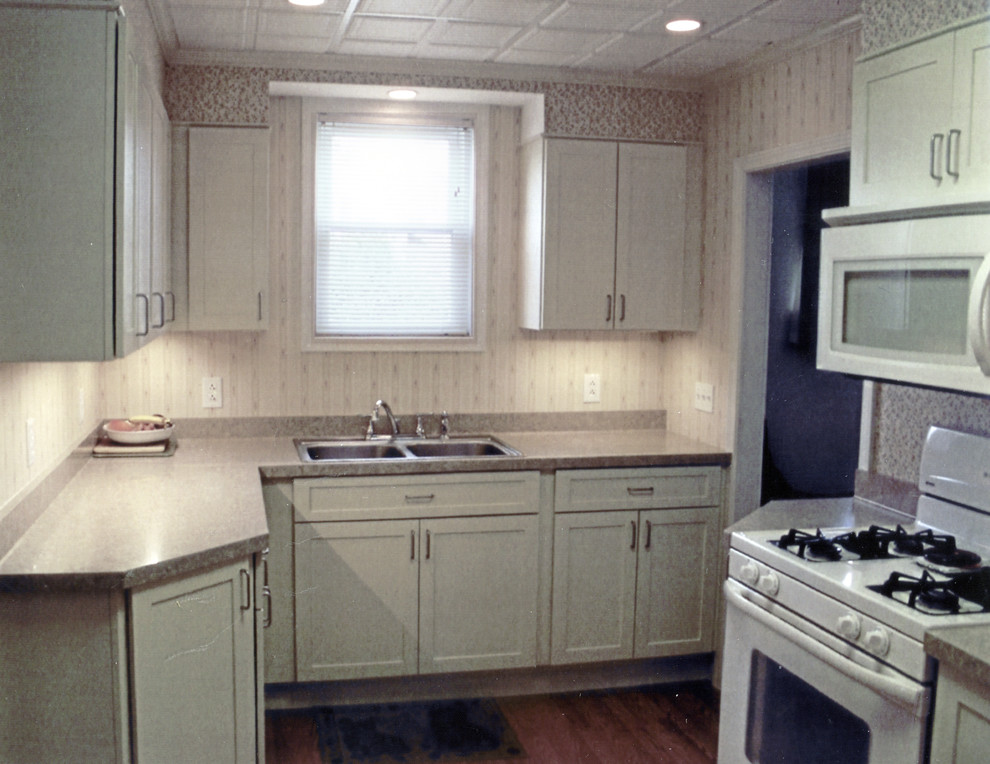 Mid-sized transitional l-shaped medium tone wood floor and brown floor kitchen pantry photo with a double-bowl sink, recessed-panel cabinets, white cabinets, laminate countertops, white appliances, no island and brown countertops