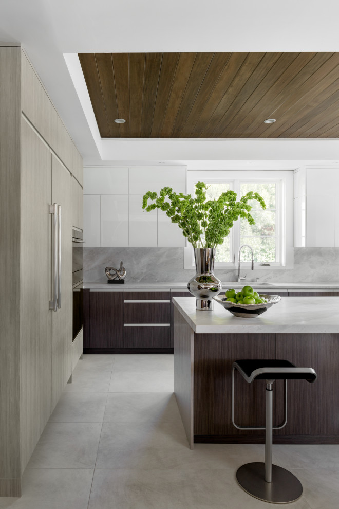 Design ideas for a large contemporary u-shaped separate kitchen in New York with an undermount sink, flat-panel cabinets, brown cabinets, marble benchtops, grey splashback, marble splashback, panelled appliances, porcelain floors, with island, grey floor and grey benchtop.