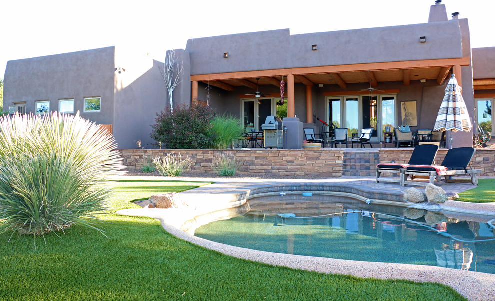 Inspiration for a large backyard custom-shaped lap pool in Phoenix with brick pavers.