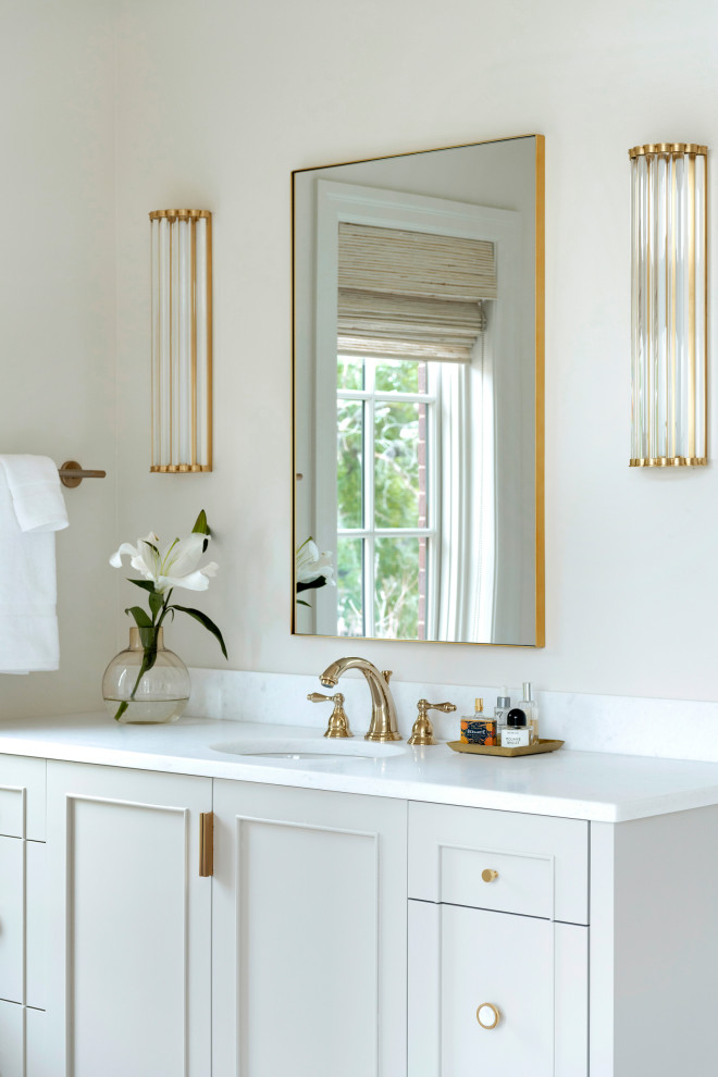 Klassisk inredning av ett mycket stort vit vitt en-suite badrum, med luckor med infälld panel, ett fristående badkar, en dusch i en alkov, dusch med gångjärnsdörr, beige skåp, en toalettstol med separat cisternkåpa, beige väggar, klinkergolv i porslin, ett undermonterad handfat, marmorbänkskiva och vitt golv