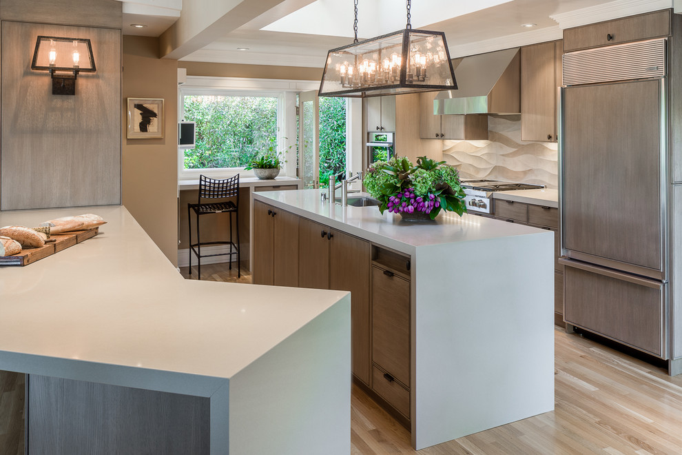 Design ideas for a mid-sized contemporary u-shaped eat-in kitchen in San Francisco with an undermount sink, flat-panel cabinets, medium wood cabinets, concrete benchtops, beige splashback, ceramic splashback, stainless steel appliances, medium hardwood floors and with island.