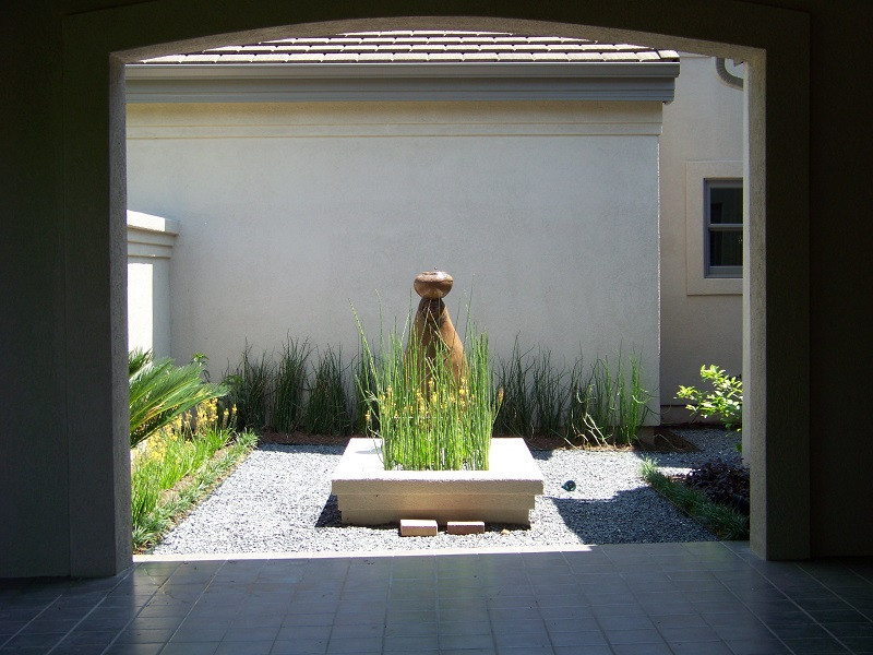 Inspiration for a mid-sized contemporary courtyard full sun xeriscape in Austin with with raised garden bed and river rock.