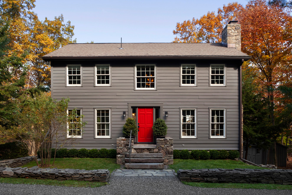 This is an example of a traditional two-storey grey house exterior in New York with wood siding, a gable roof and a shingle roof.