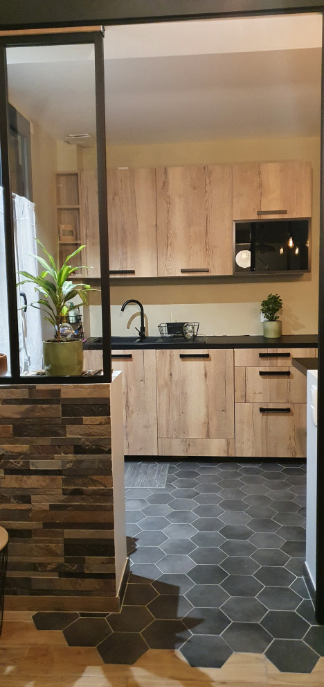 Inspiration for a mid-sized industrial l-shaped open plan kitchen in Paris with an undermount sink, shaker cabinets, light wood cabinets, laminate benchtops, stainless steel appliances, cement tiles, no island, grey floor and black benchtop.