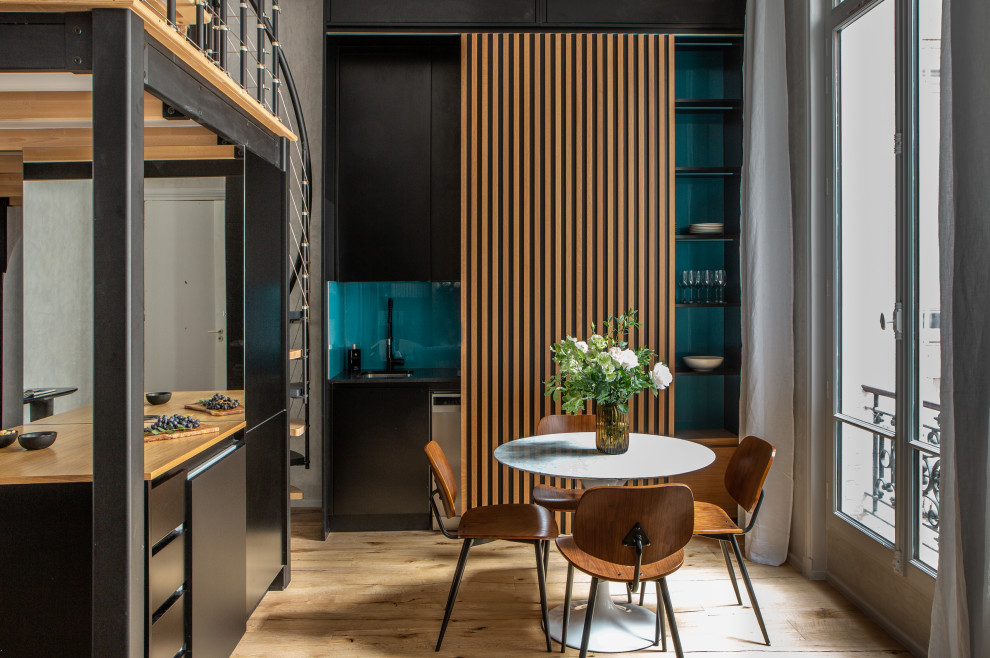 Idee per una piccola sala da pranzo aperta verso la cucina moderna con parquet chiaro, pavimento marrone e pareti in legno
