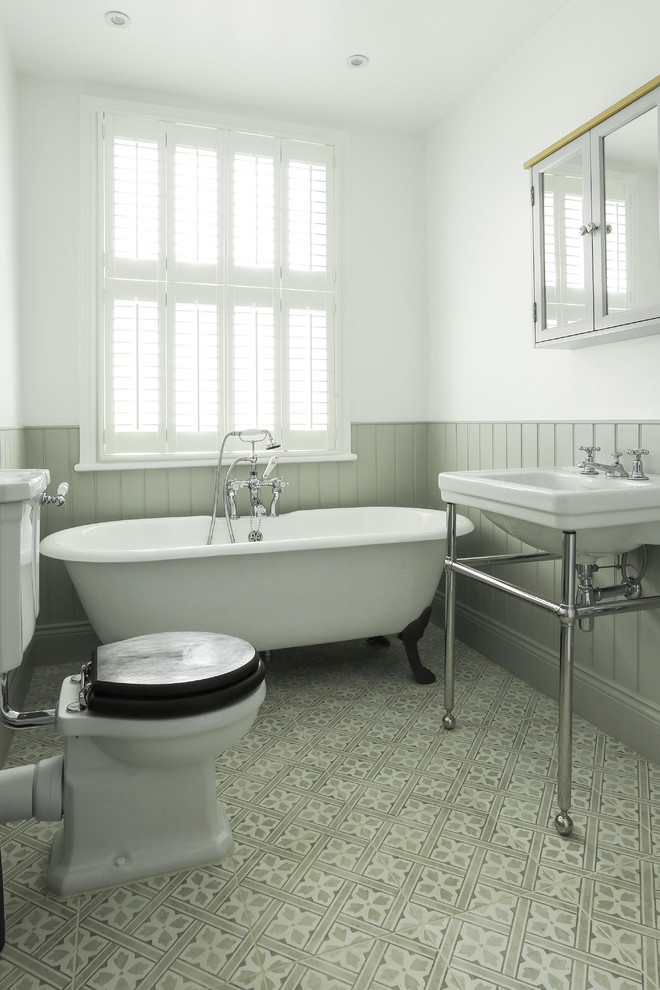 Design ideas for a mid-sized traditional kids bathroom in London with a two-piece toilet, white walls, cement tiles, a console sink, a claw-foot tub and grey floor.