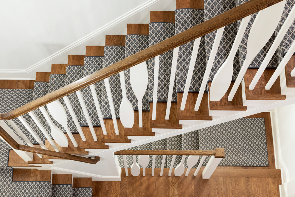 Idée de décoration pour un grand escalier peint marin en U avec des marches en bois et un garde-corps en bois.
