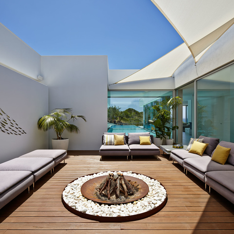 This is an example of a contemporary deck in Other with a fire feature.