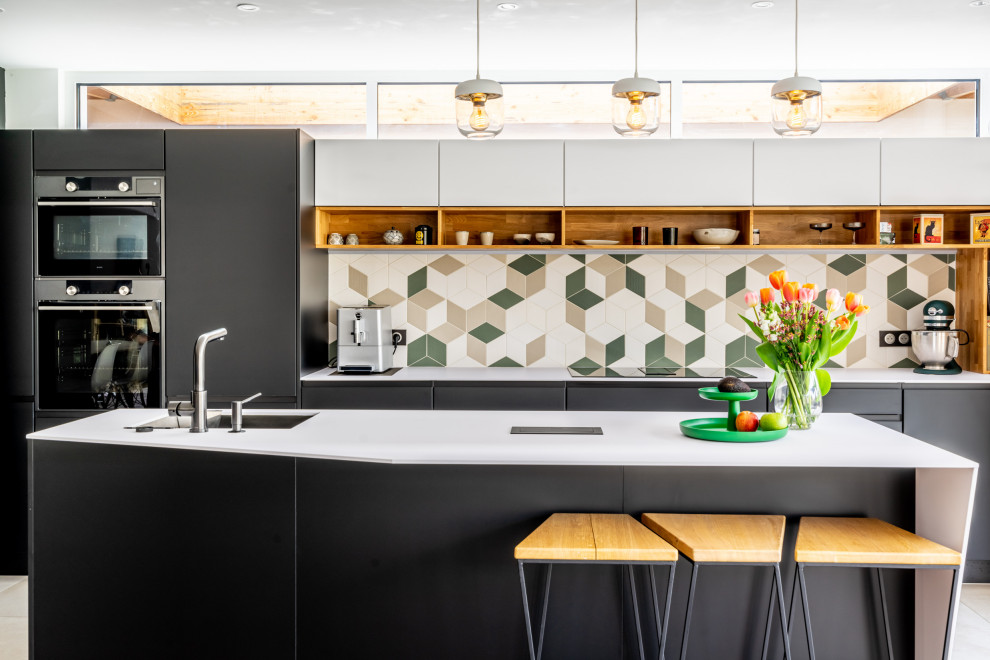 Inspiration för mellanstora moderna linjära vitt kök med öppen planlösning, med en undermonterad diskho, släta luckor, svarta skåp, bänkskiva i koppar, flerfärgad stänkskydd, svarta vitvaror, klinkergolv i keramik, en köksö och grått golv