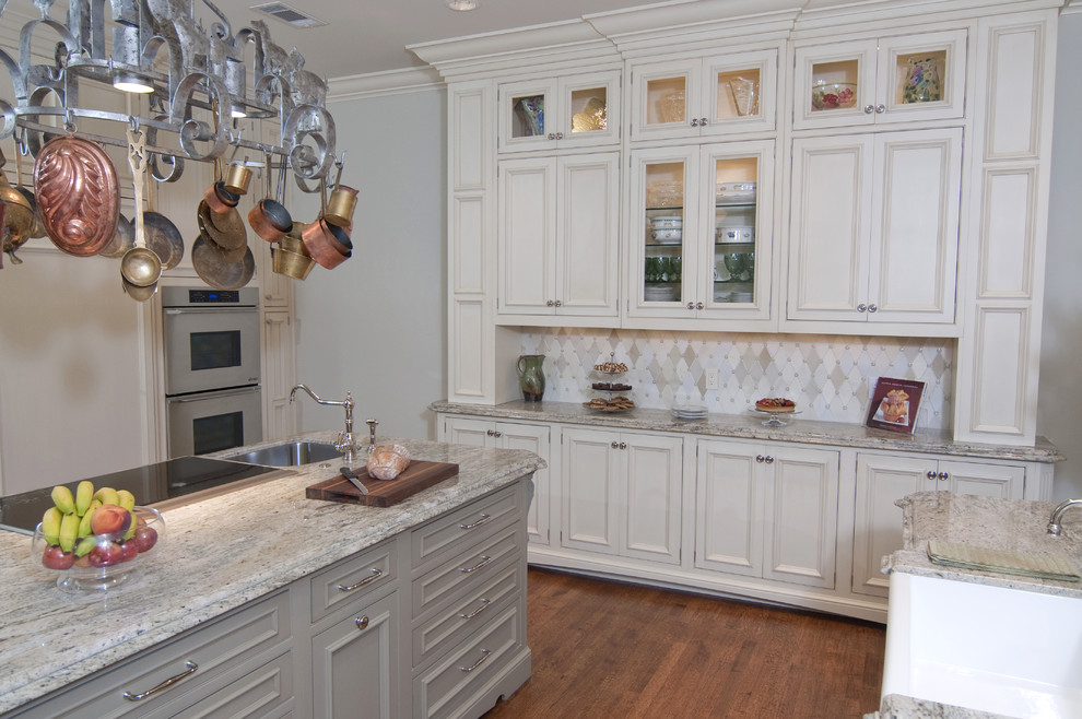 Inspiration for a traditional u-shaped eat-in kitchen in Dallas with a farmhouse sink, recessed-panel cabinets, green cabinets, granite benchtops, beige splashback and stone tile splashback.