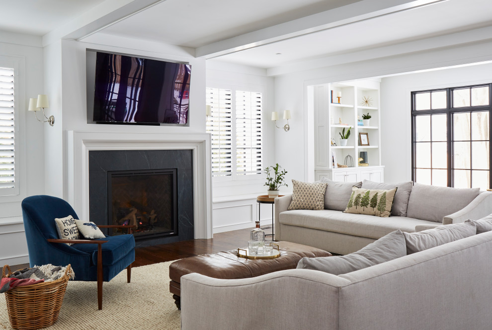 Design ideas for a large country open concept family room in Chicago with white walls, medium hardwood floors, a standard fireplace, a stone fireplace surround, a wall-mounted tv, brown floor and exposed beam.