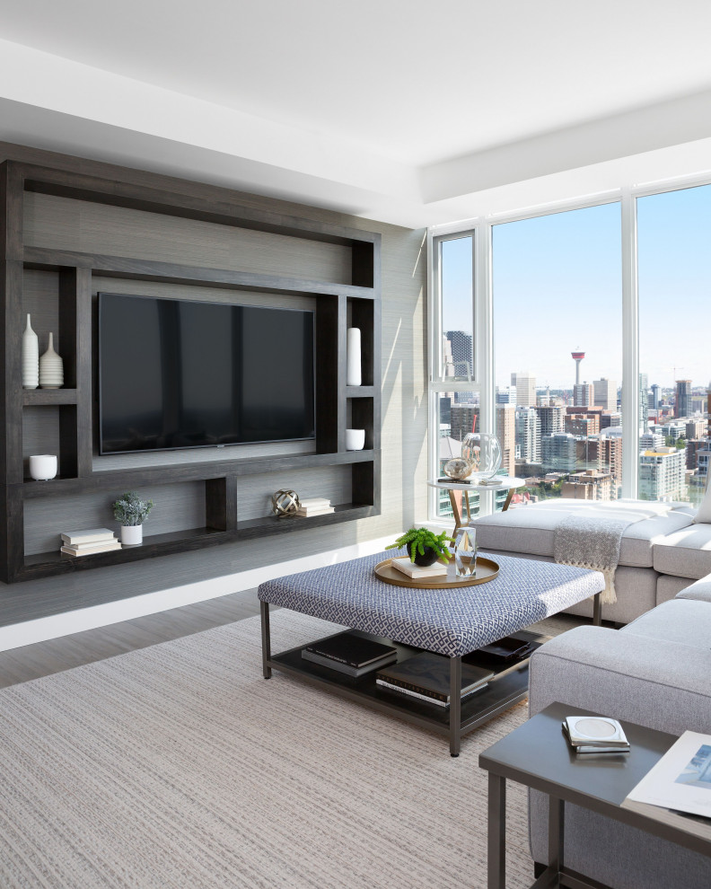 This is an example of a contemporary living room in Calgary with grey walls, a wall-mounted tv and grey floor.