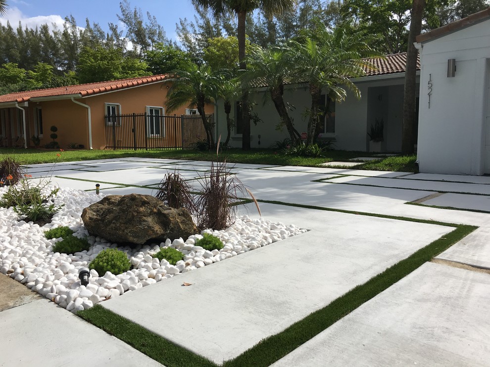 Design ideas for a mid-sized contemporary front yard partial sun driveway in Miami with concrete pavers.