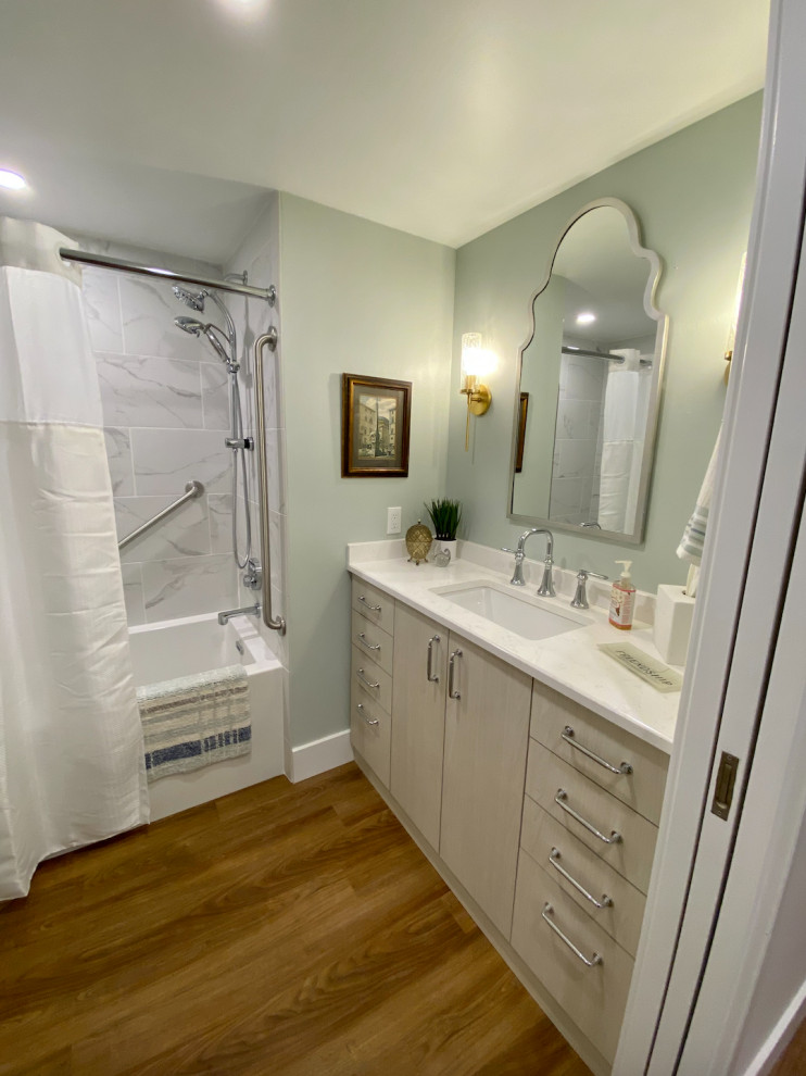 Exempel på ett mellanstort klassiskt vit vitt badrum, med släta luckor, skåp i ljust trä, ett badkar i en alkov, en dusch/badkar-kombination, en toalettstol med separat cisternkåpa, gröna väggar, vinylgolv, ett undermonterad handfat, bänkskiva i kvartsit, brunt golv och dusch med duschdraperi
