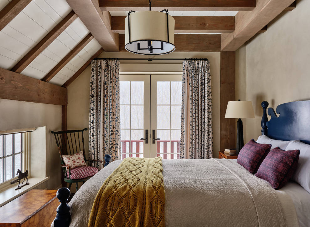 Immagine di una camera da letto country con pareti beige, travi a vista e soffitto in perlinato