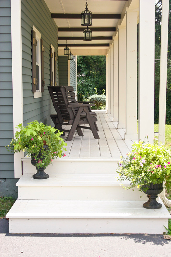 Inspiration for a mid-sized craftsman front porch remodel in New York with decking and a roof extension