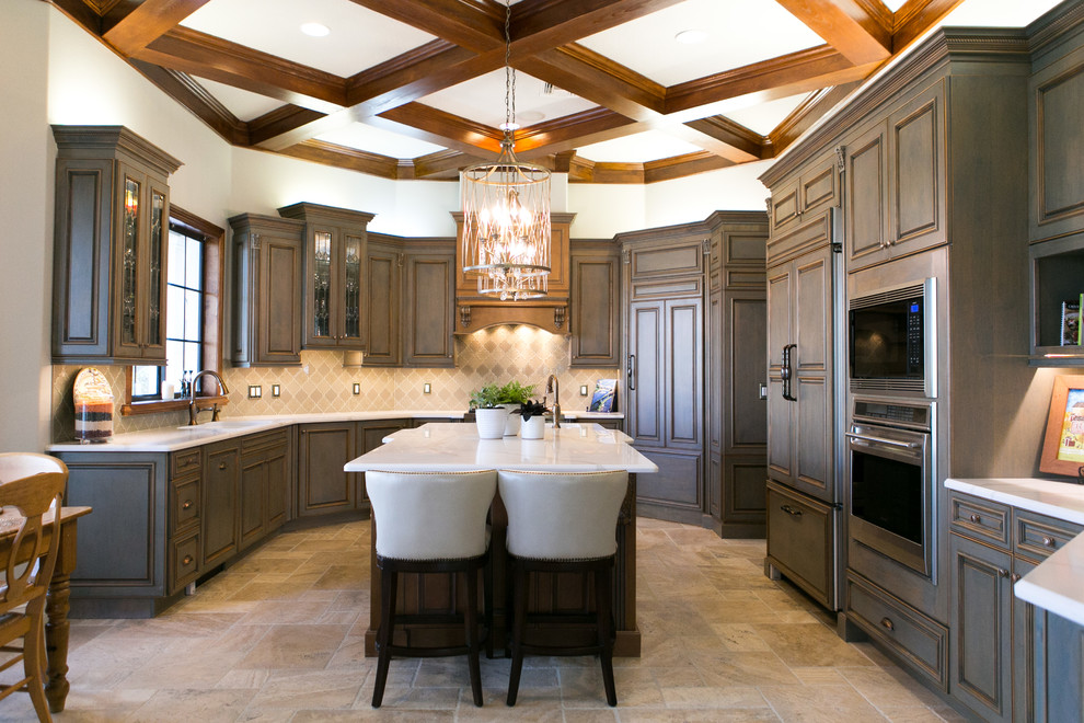 This is an example of a large traditional kitchen in Orlando with raised-panel cabinets, quartzite benchtops, beige splashback, porcelain floors, with island, beige floor, dark wood cabinets, panelled appliances and white benchtop.